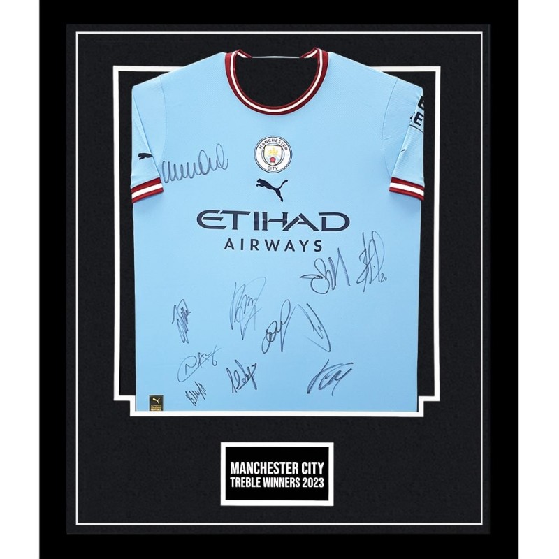 Maglia firmata e incorniciata della squadra vincitrice del Treble del Manchester City 2022/23