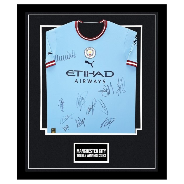 Maglia firmata e incorniciata della squadra vincitrice del Treble del Manchester City 2022/23