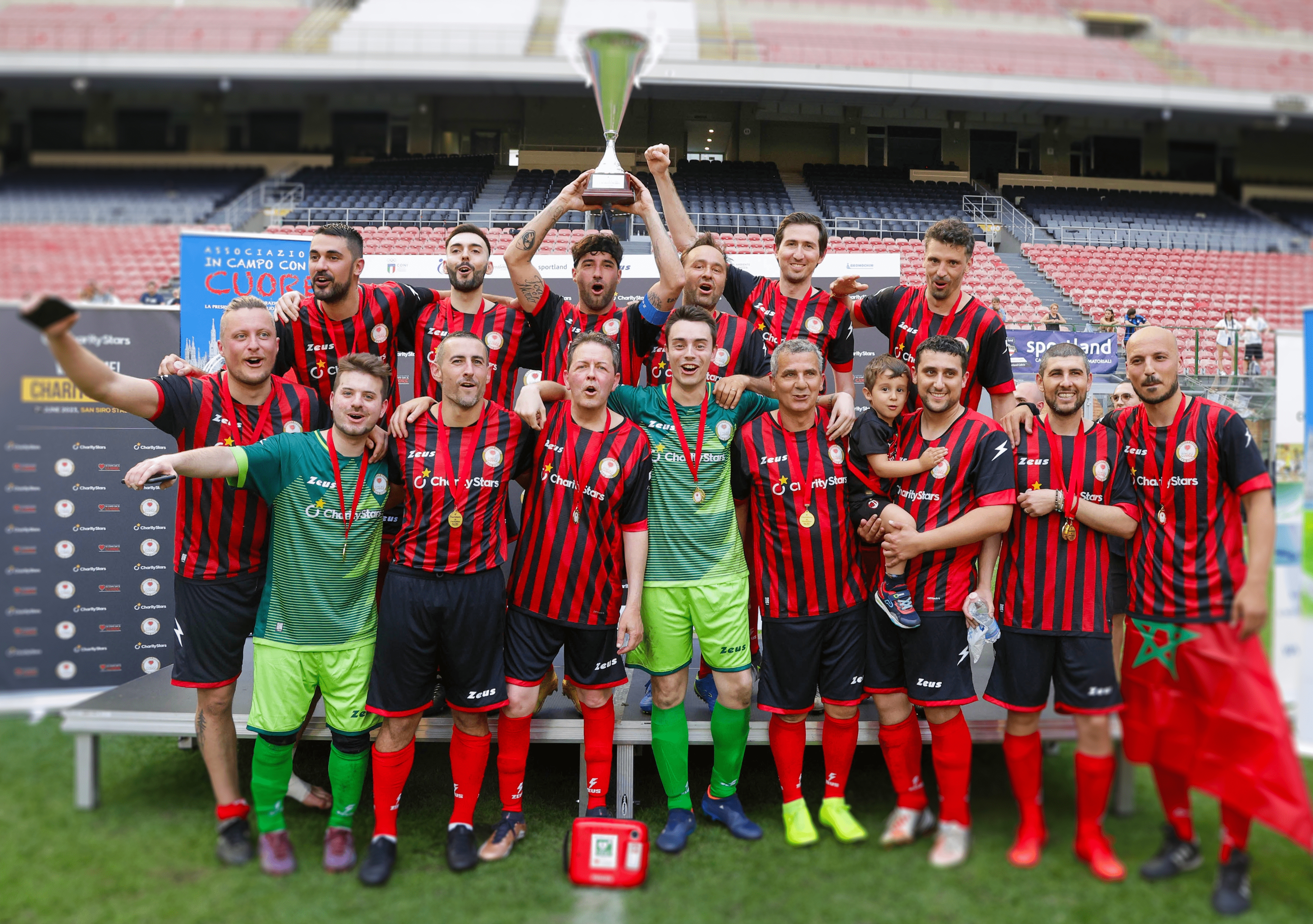 Rossoneri team celebrating as they raise the CharityDerby trophy