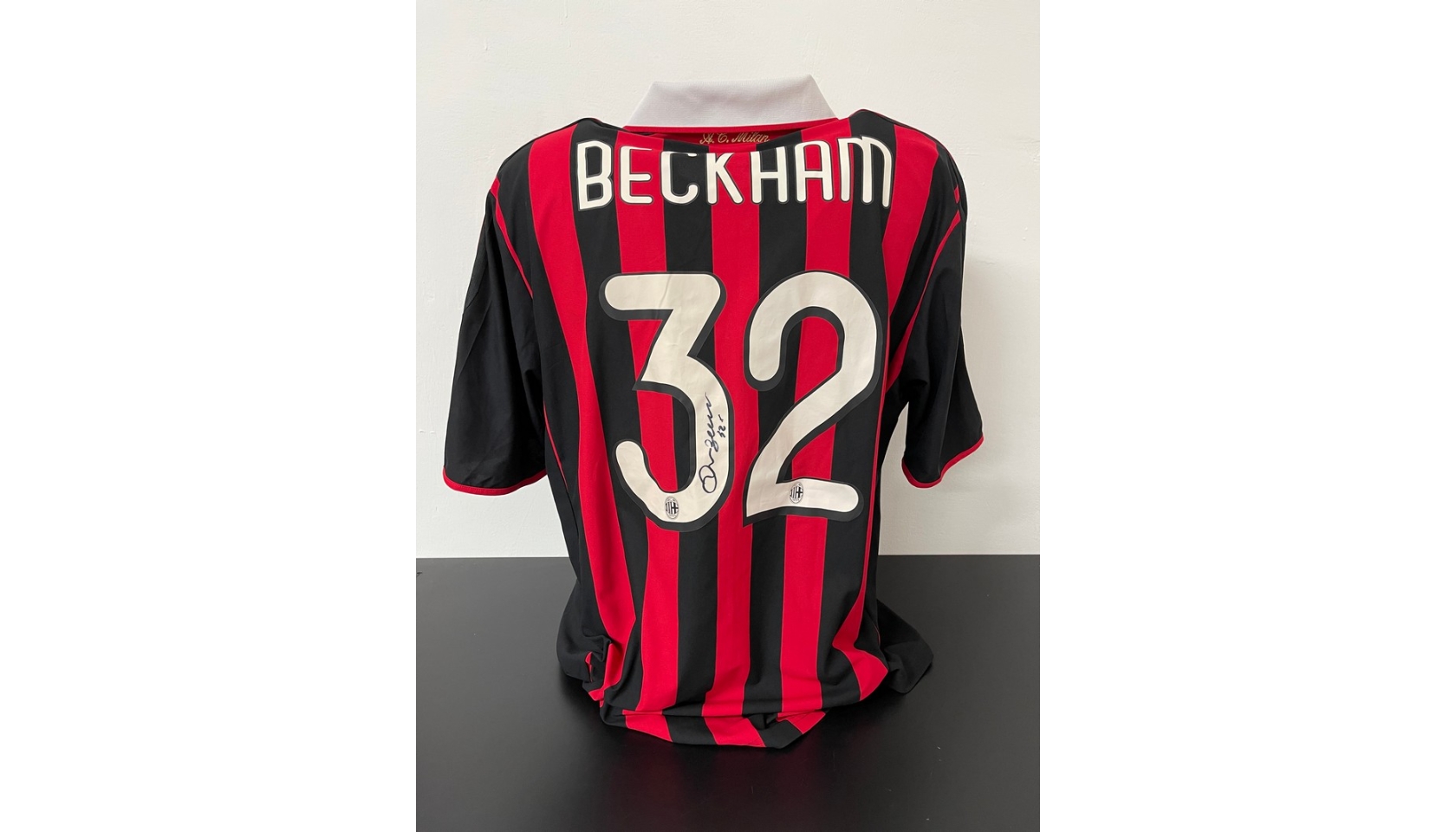 A framed and A.C. Milan football jersey signed by David Beckham